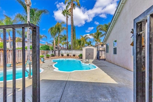 view of swimming pool with a fenced in pool, a patio area, a shed, a fenced backyard, and an outdoor structure