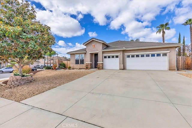 view of front of house featuring a garage, fence, concrete driveway, and stucco siding