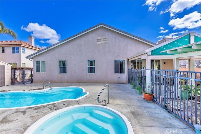 view of pool with a patio, fence, a fenced in pool, and an in ground hot tub