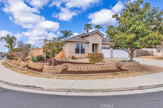 ranch-style home with a garage, fence, concrete driveway, and stucco siding