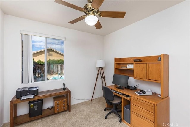 home office featuring light carpet and ceiling fan