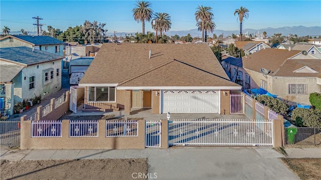 view of front of property featuring a fenced front yard, a residential view, driveway, and a garage