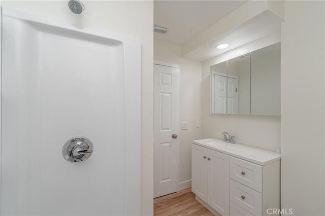 bathroom featuring visible vents, wood finished floors, and vanity