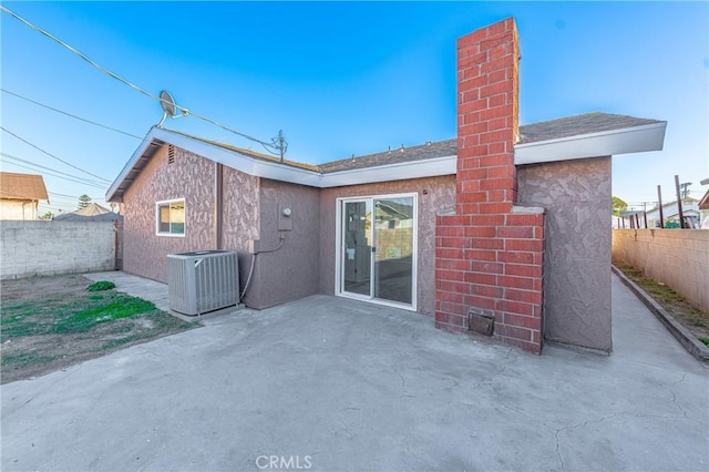 rear view of property with central AC, a patio, a fenced backyard, and stucco siding