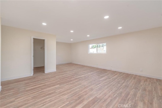 empty room with recessed lighting, light wood-style flooring, and baseboards