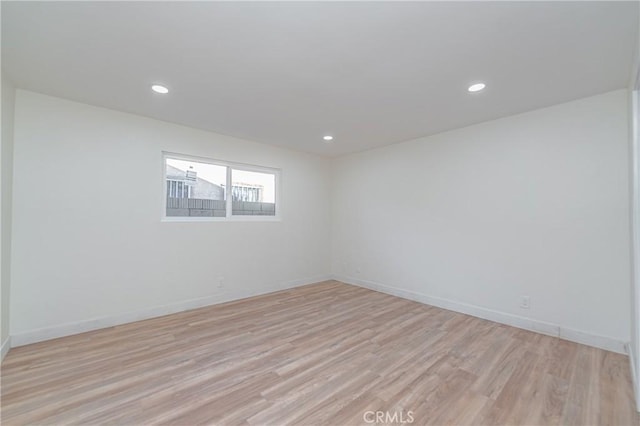 spare room with light wood-type flooring, baseboards, and recessed lighting