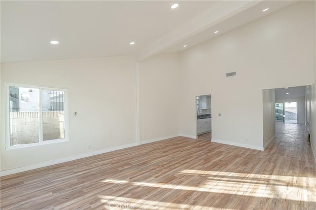 unfurnished room featuring recessed lighting, visible vents, baseboards, beam ceiling, and light wood finished floors