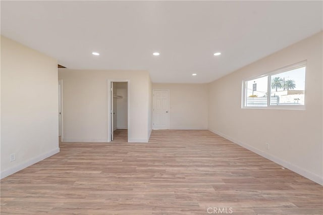 unfurnished room featuring baseboards, light wood-style flooring, and recessed lighting