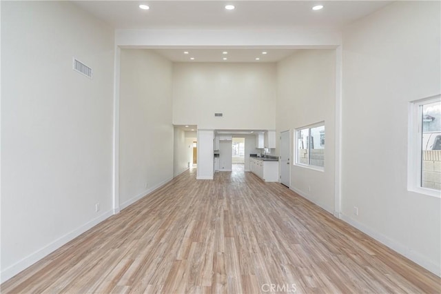 unfurnished living room with light wood finished floors, baseboards, visible vents, and recessed lighting