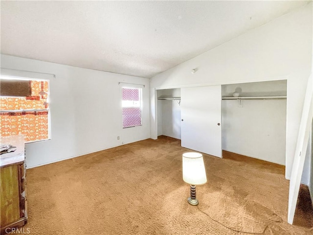 unfurnished bedroom featuring vaulted ceiling, a textured ceiling, carpet, and a closet