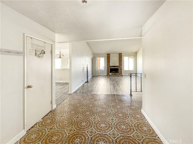 interior space with tile patterned flooring, a textured ceiling, and baseboards