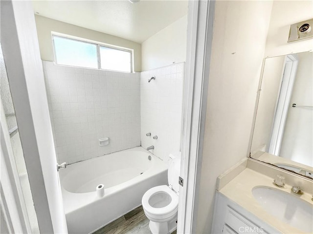 full bathroom featuring toilet, vanity, wood finished floors, and bathing tub / shower combination