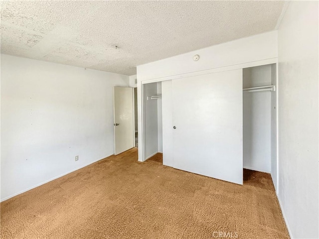 unfurnished bedroom featuring a closet, carpet flooring, and a textured ceiling