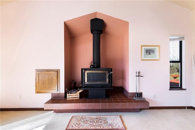interior details with baseboards, carpet, and a wood stove