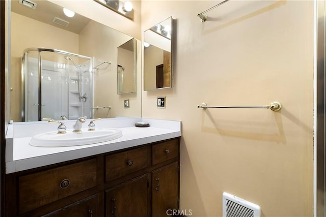 bathroom with vanity, visible vents, heating unit, and a stall shower
