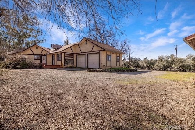 view of front of home with a garage, driveway, and stucco siding