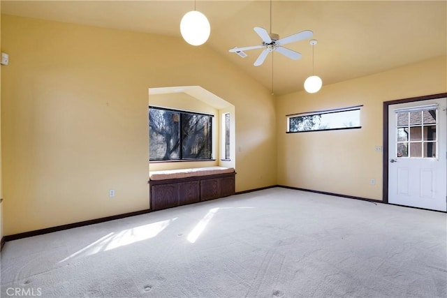 spare room with baseboards, light carpet, a ceiling fan, and lofted ceiling