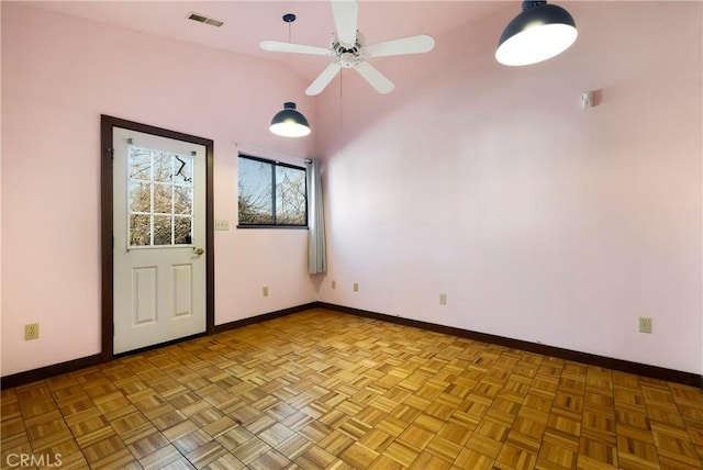 empty room featuring baseboards, a ceiling fan, lofted ceiling, and visible vents