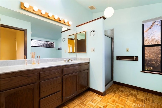 full bath with visible vents, baseboards, a stall shower, and vanity