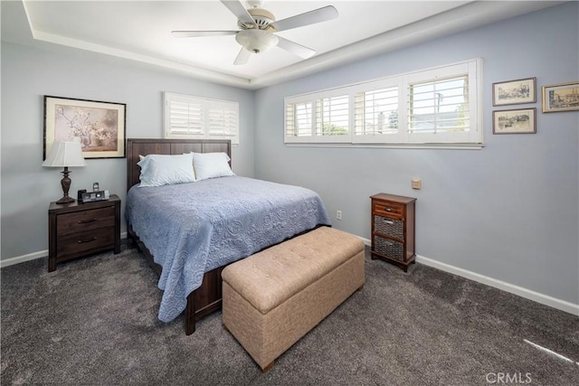 bedroom featuring carpet floors, ceiling fan, baseboards, and a raised ceiling