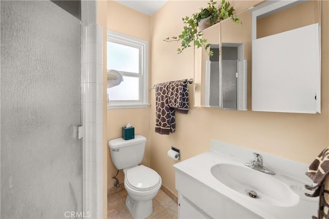 bathroom with a shower with door, vanity, toilet, and tile patterned floors