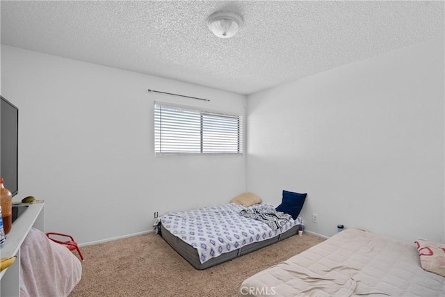 bedroom featuring a textured ceiling, carpet, and baseboards