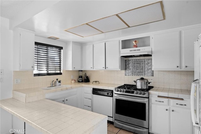 kitchen featuring stainless steel range with gas cooktop, white cabinets, white dishwasher, a peninsula, and under cabinet range hood