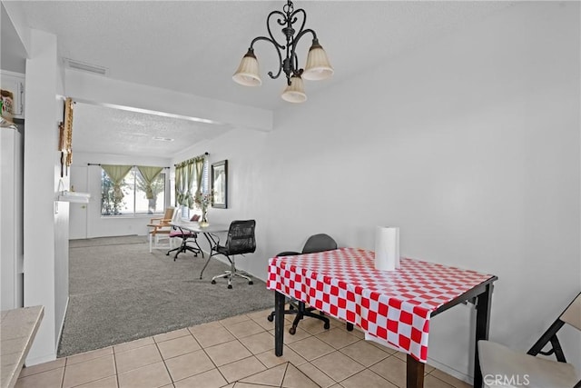 carpeted dining area featuring a textured ceiling, tile patterned flooring, a chandelier, and visible vents