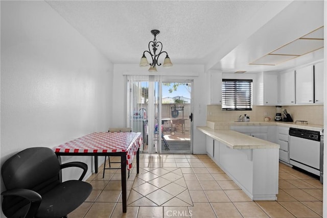 kitchen with light tile patterned floors, tasteful backsplash, white cabinets, a peninsula, and white dishwasher