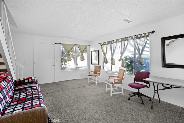 sitting room featuring carpet floors, visible vents, and a textured ceiling