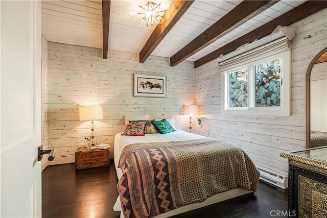 bedroom with wooden walls, a baseboard heating unit, beamed ceiling, and wood finished floors