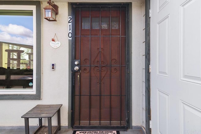 entrance to property featuring stucco siding