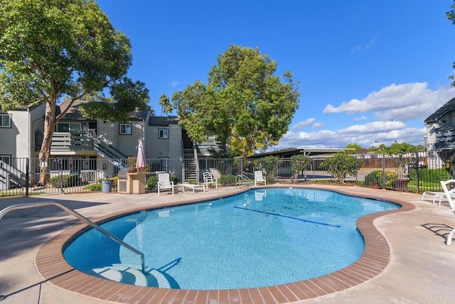 community pool featuring fence and a patio