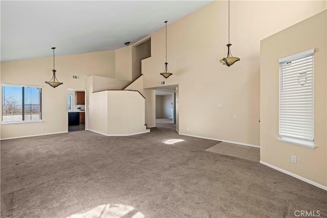 unfurnished living room featuring high vaulted ceiling, carpet, visible vents, and baseboards