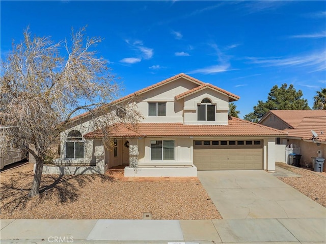 mediterranean / spanish home with a garage, a tile roof, concrete driveway, and stucco siding