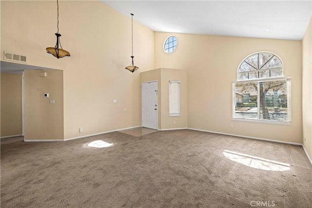 unfurnished living room featuring high vaulted ceiling, carpet, visible vents, and baseboards