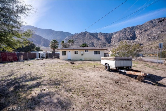 rear view of house with fence and a mountain view