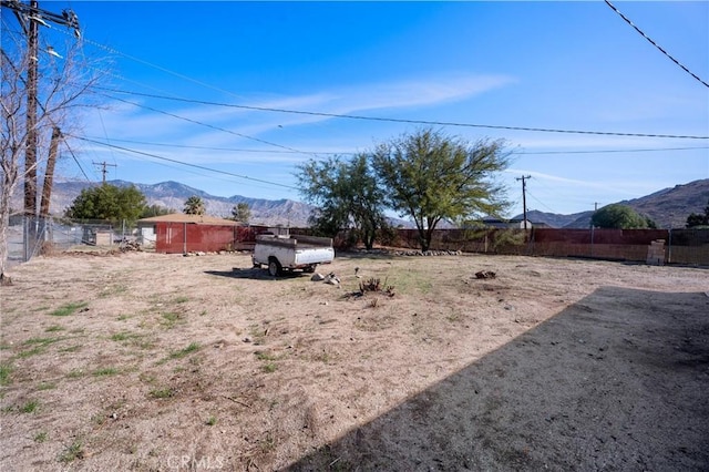 view of yard with fence and a mountain view