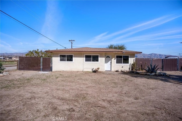 ranch-style house with fence and stucco siding