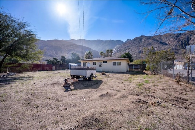 back of house with fence and a mountain view