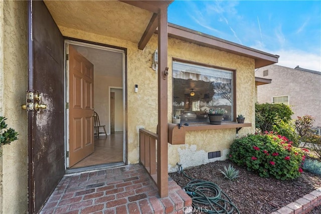 property entrance with crawl space and stucco siding