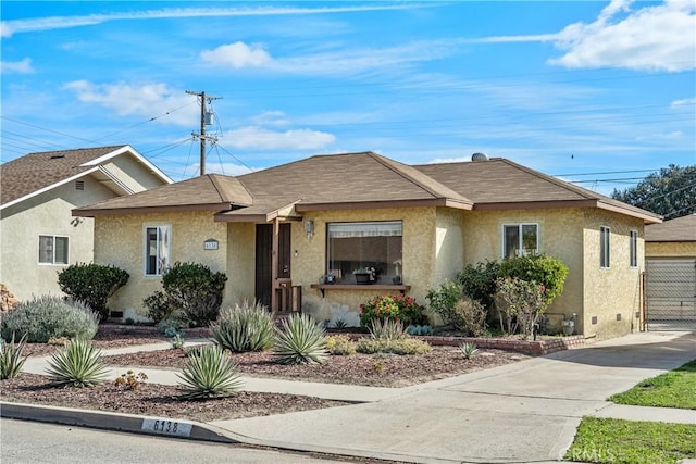 view of front of property with a garage, roof with shingles, fence, and stucco siding