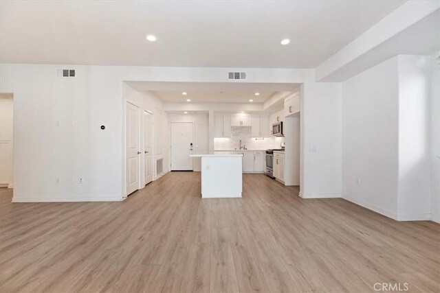 unfurnished living room featuring recessed lighting, visible vents, light wood-style flooring, and baseboards