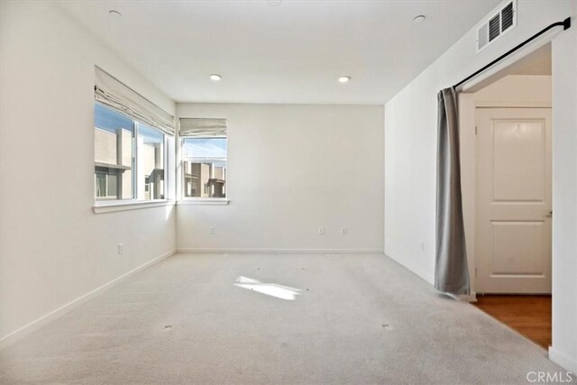 carpeted spare room with recessed lighting, visible vents, and baseboards