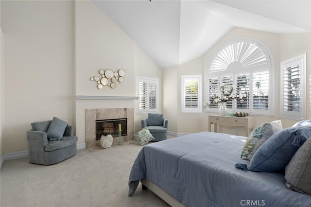 carpeted bedroom featuring lofted ceiling, multiple windows, a fireplace, and baseboards