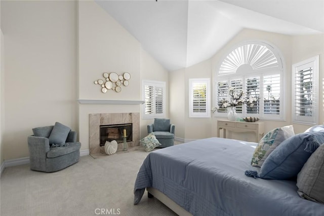 bedroom featuring carpet flooring, a high end fireplace, multiple windows, and vaulted ceiling