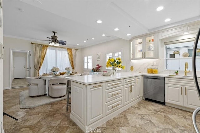 kitchen with dishwasher, a peninsula, white cabinets, and crown molding