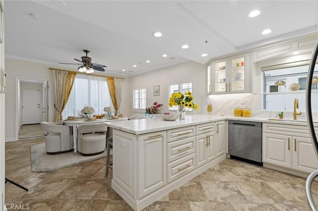 kitchen with tasteful backsplash, ornamental molding, a peninsula, white cabinets, and dishwasher