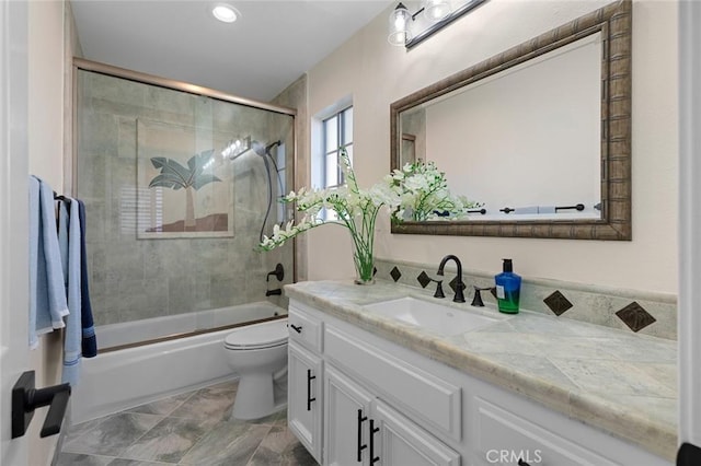 full bath featuring toilet, vanity, and bath / shower combo with glass door