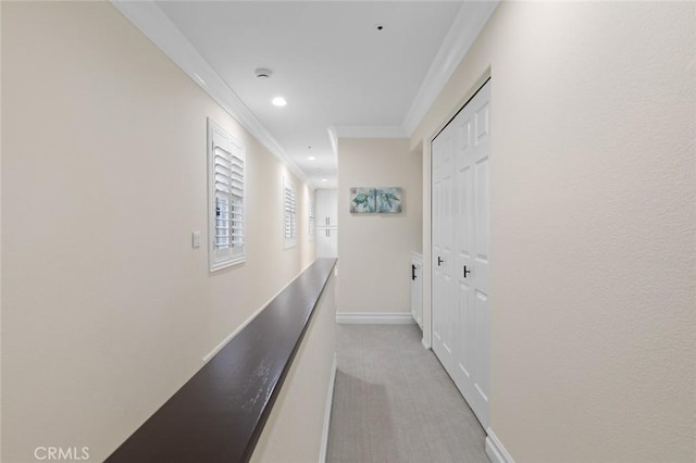 hallway with recessed lighting, light colored carpet, crown molding, and baseboards